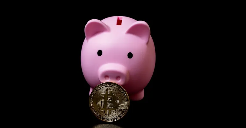 Pink piggy bank holding a bitcoin coin symbolizing modern digital investments.