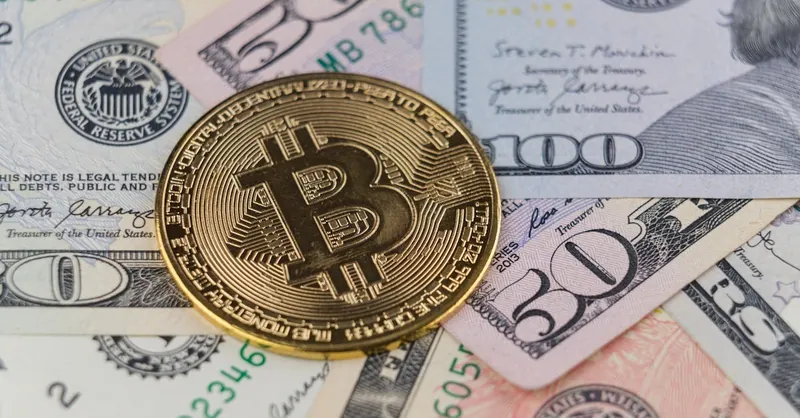 Close-up of a Bitcoin coin on US dollar banknotes, symbolizing cryptocurrency and traditional finance.