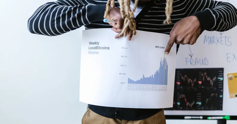 Businessperson presenting a chart on weekly Bitcoin volume trends with detailed analysis.