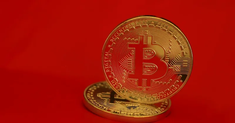 Close-up of golden Bitcoin coins with a red background, symbolizing digital currency and blockchain technology.