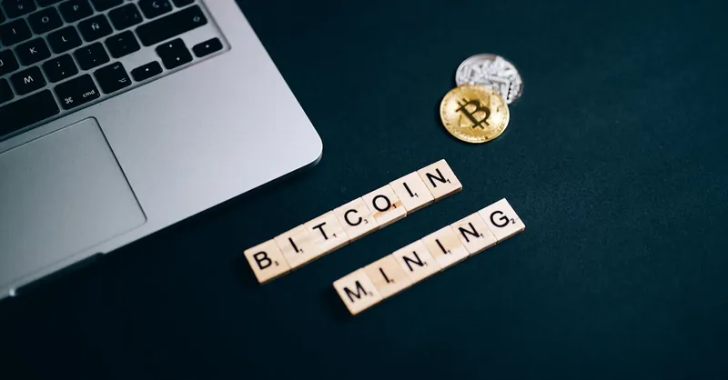 Top view of Bitcoin mining concept represented with laptop keyboard and Scrabble tiles.