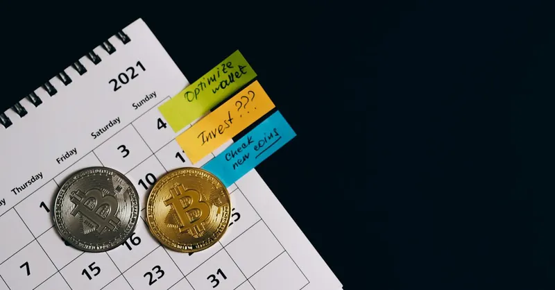 Close-up of Bitcoins on a calendar highlighting investment plans with sticky notes.